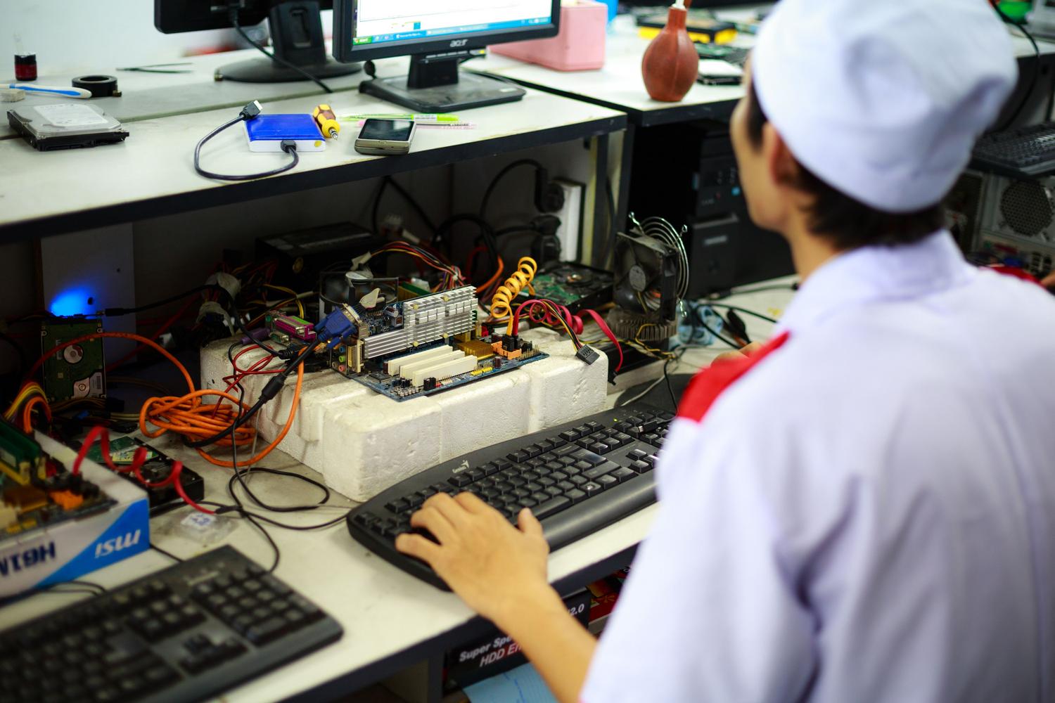 Technician performing hardware diagnostics on an open-bench motherboard setup to audit system stability. Technician performing hardware diagnostics on an open-bench motherboard setup to audit system stability.