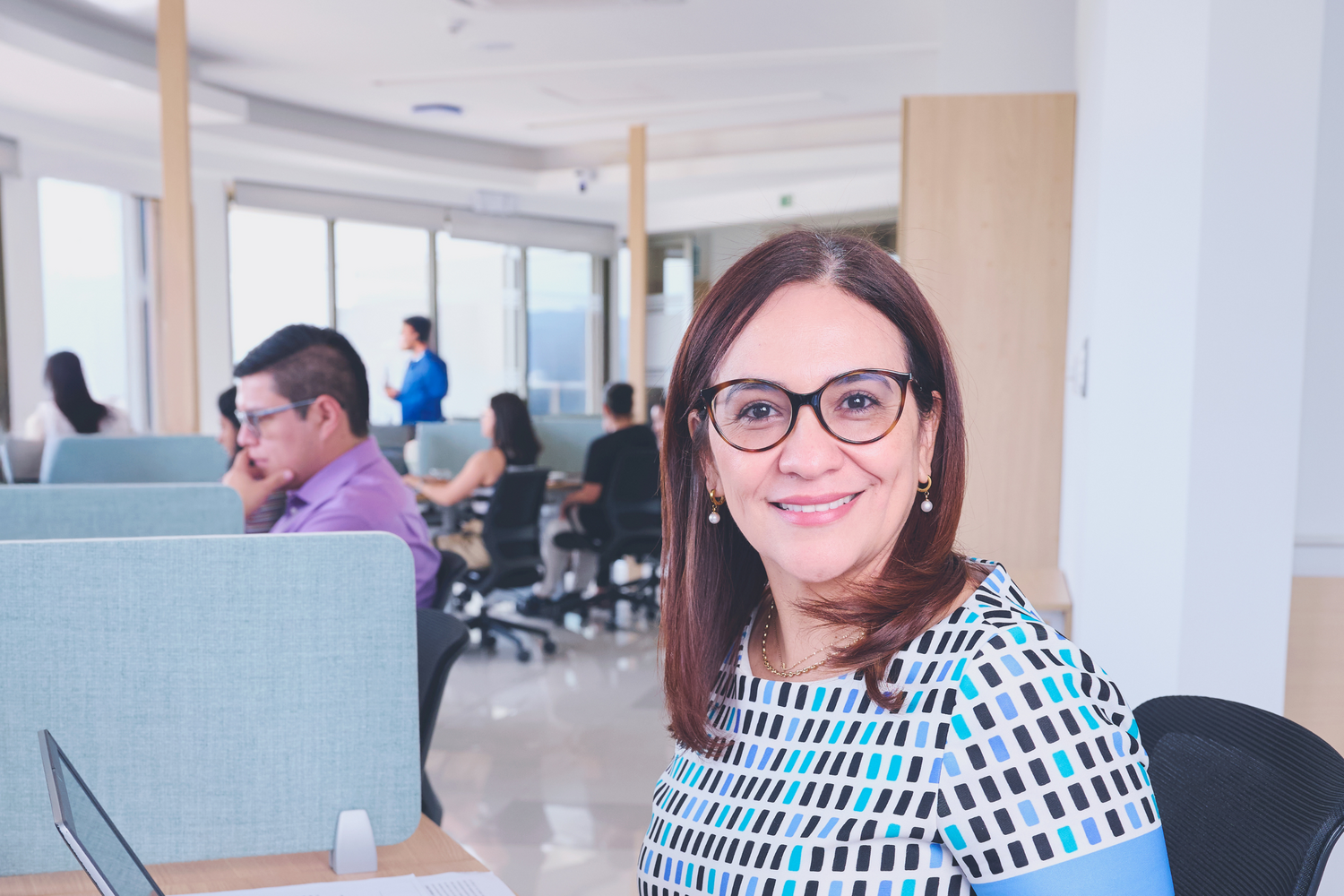 Mujer profesional sonriendo en una oficina moderna y luminosa, transmitiendo confianza y liderazgo en la gestión de talento. Mujer profesional sonriendo en una oficina moderna y luminosa, transmitiendo confianza y liderazgo en la gestión de talento.