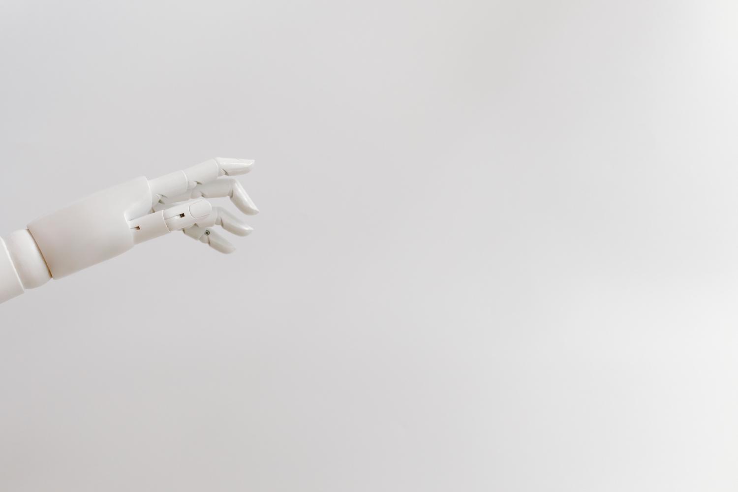 Mano robótica minimalista en color blanco sobre un fondo blanco puro, representando la innovación y la tecnología de IA. Mano robótica minimalista en color blanco sobre un fondo blanco puro, representando la innovación y la tecnología de IA.
