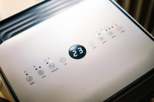 Primer plano de un panel de control de aire acondicionado moderno mostrando la temperatura.