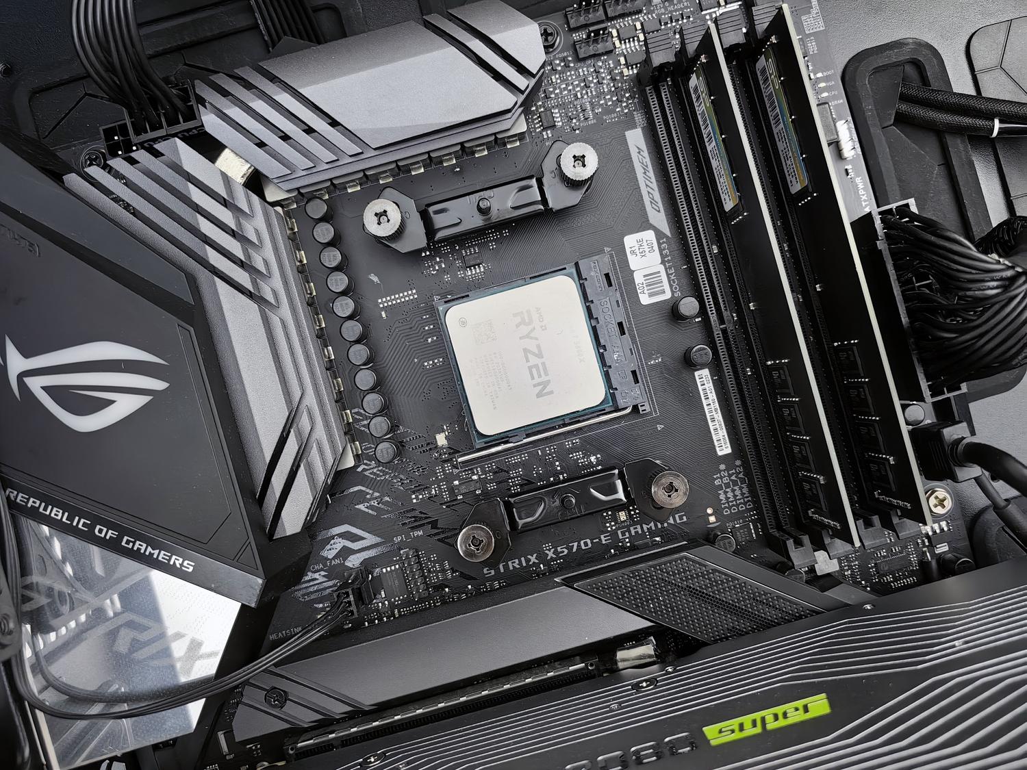 Vista detallada del interior de un PC gaming con una placa base ASUS ROG y un procesador AMD Ryzen instalado. Vista detallada del interior de un PC gaming con una placa base ASUS ROG y un procesador AMD Ryzen instalado.
