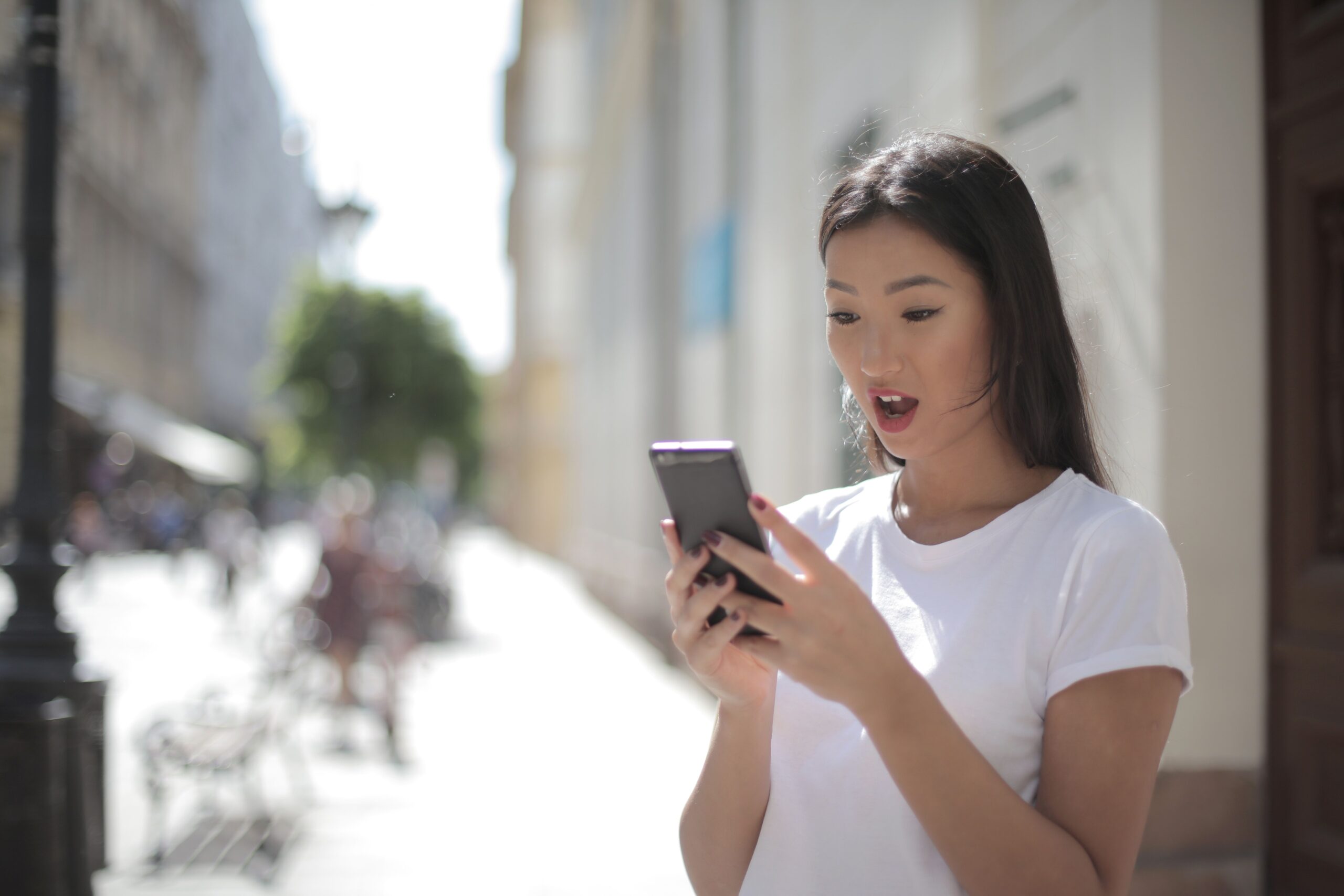 Mujer sorprendida al interactuar con su iPhone, ejemplificando la potencia y naturalidad de Apple Intelligence en iOS 26. Mujer sorprendida al interactuar con su iPhone, ejemplificando la potencia y naturalidad de Apple Intelligence en iOS 26.