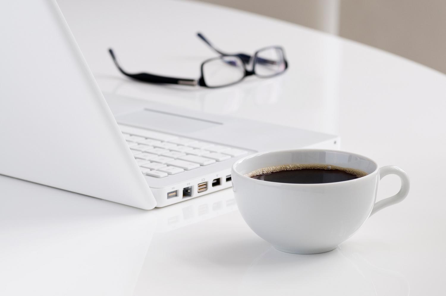Espacio de trabajo minimalista y luminoso con gafas y un portátil, ejemplificando la optimización del entorno y la ergonomía visual. Espacio de trabajo minimalista y luminoso con gafas y un portátil, ejemplificando la optimización del entorno y la ergonomía visual.