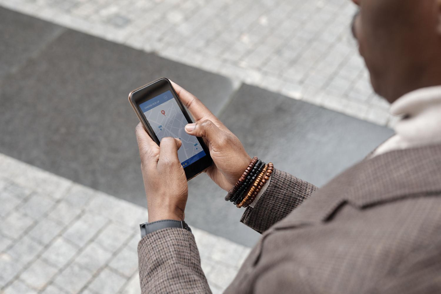 Persona utilizando una aplicación de navegación en un entorno urbano, ejemplificando el uso práctico de las APIs de ubicación. Persona utilizando una aplicación de navegación en un entorno urbano, ejemplificando el uso práctico de las APIs de ubicación.