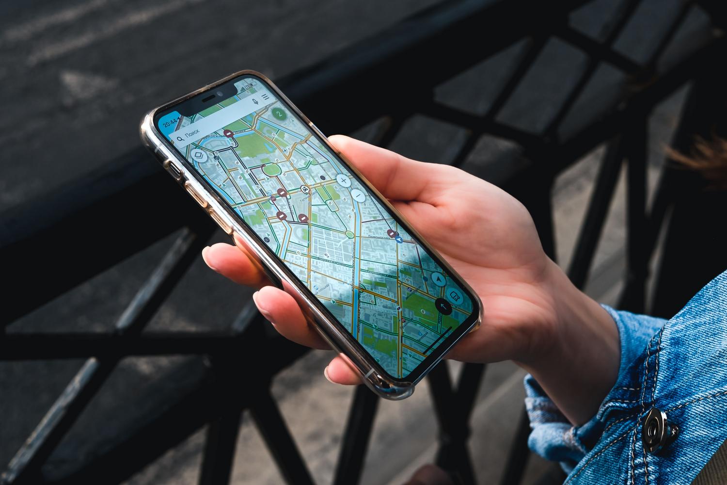 Primer plano de una mano sosteniendo un smartphone con una aplicación de mapas, representando la geolocalización en dispositivos móviles. Primer plano de una mano sosteniendo un smartphone con una aplicación de mapas, representando la geolocalización en dispositivos móviles.