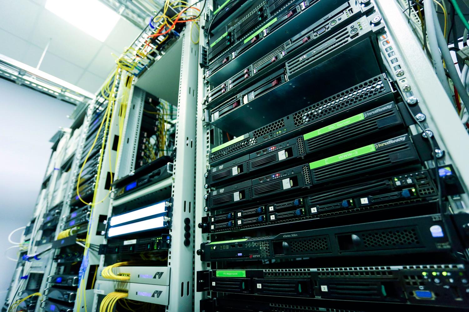 Pasillo de racks de servidores en un centro de datos moderno con cables de fibra óptica, ilustrando la infraestructura técnica y la ciberseguridad robusta. Pasillo de racks de servidores en un centro de datos moderno con cables de fibra óptica, ilustrando la infraestructura técnica y la ciberseguridad robusta.