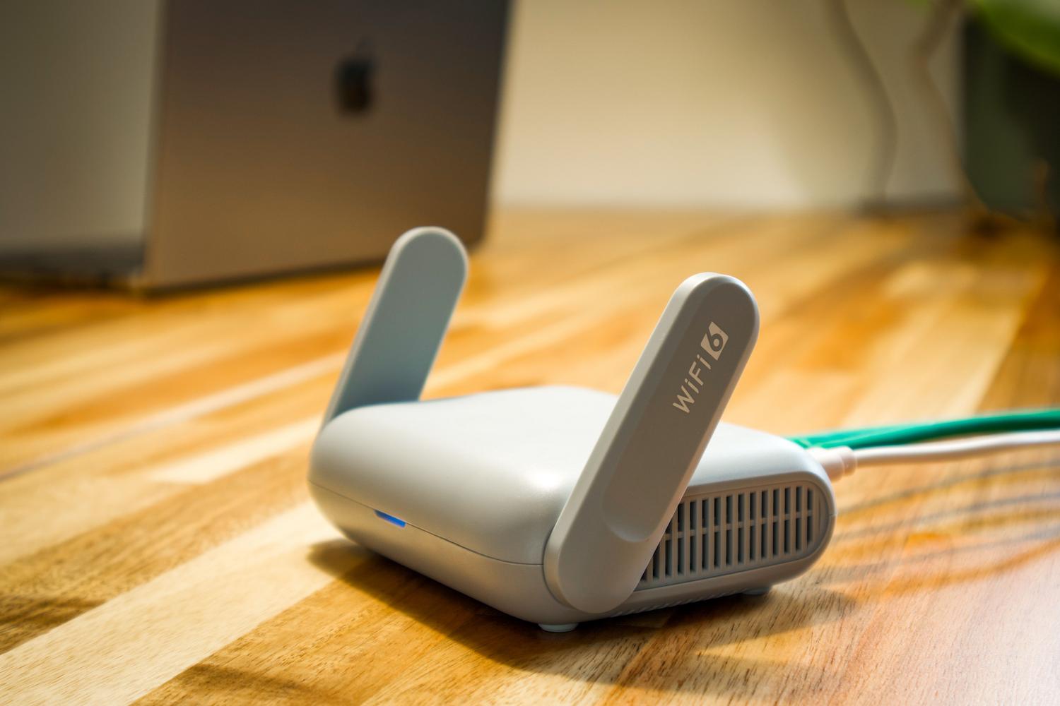Router WiFi moderno en un escritorio, ideal para ilustrar la implementación de redes domésticas de alta velocidad. Router WiFi moderno en un escritorio, ideal para ilustrar la implementación de redes domésticas de alta velocidad.