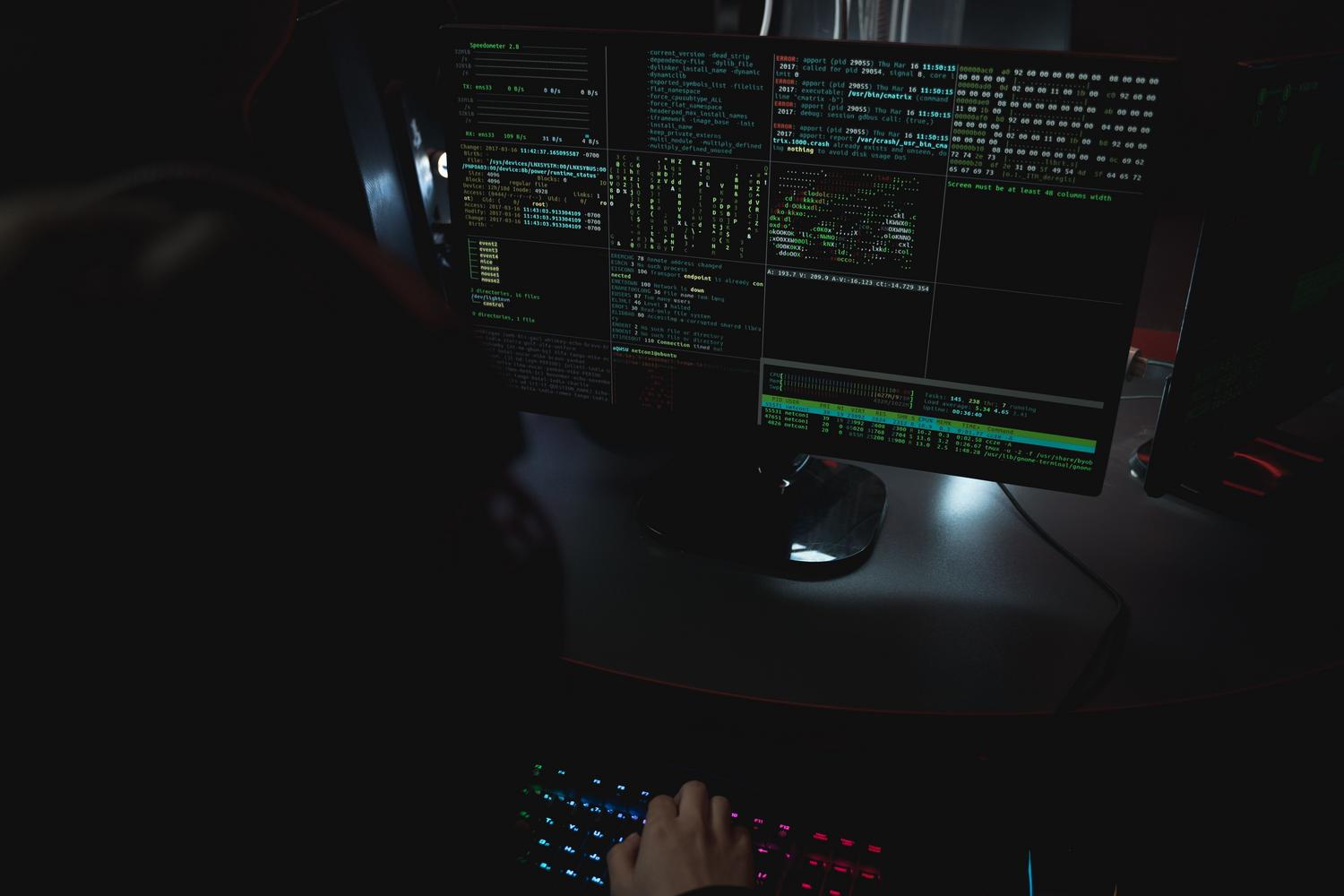 Pantallas de ordenador con líneas de código en una sala oscura, ilustrando la ciberseguridad y el Red Teaming aplicado a la bioseguridad. Pantallas de ordenador con líneas de código en una sala oscura, ilustrando la ciberseguridad y el Red Teaming aplicado a la bioseguridad.