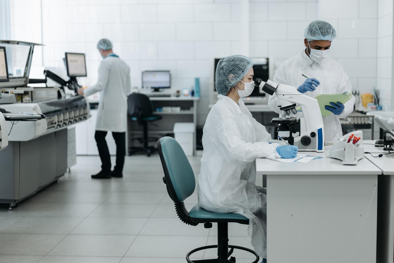 Investigadores con equipo de protección individual (EPI) en un laboratorio de alta tecnología, destacando los protocolos de bioseguridad. Investigadores con equipo de protección individual (EPI) en un laboratorio de alta tecnología, destacando los protocolos de bioseguridad.
