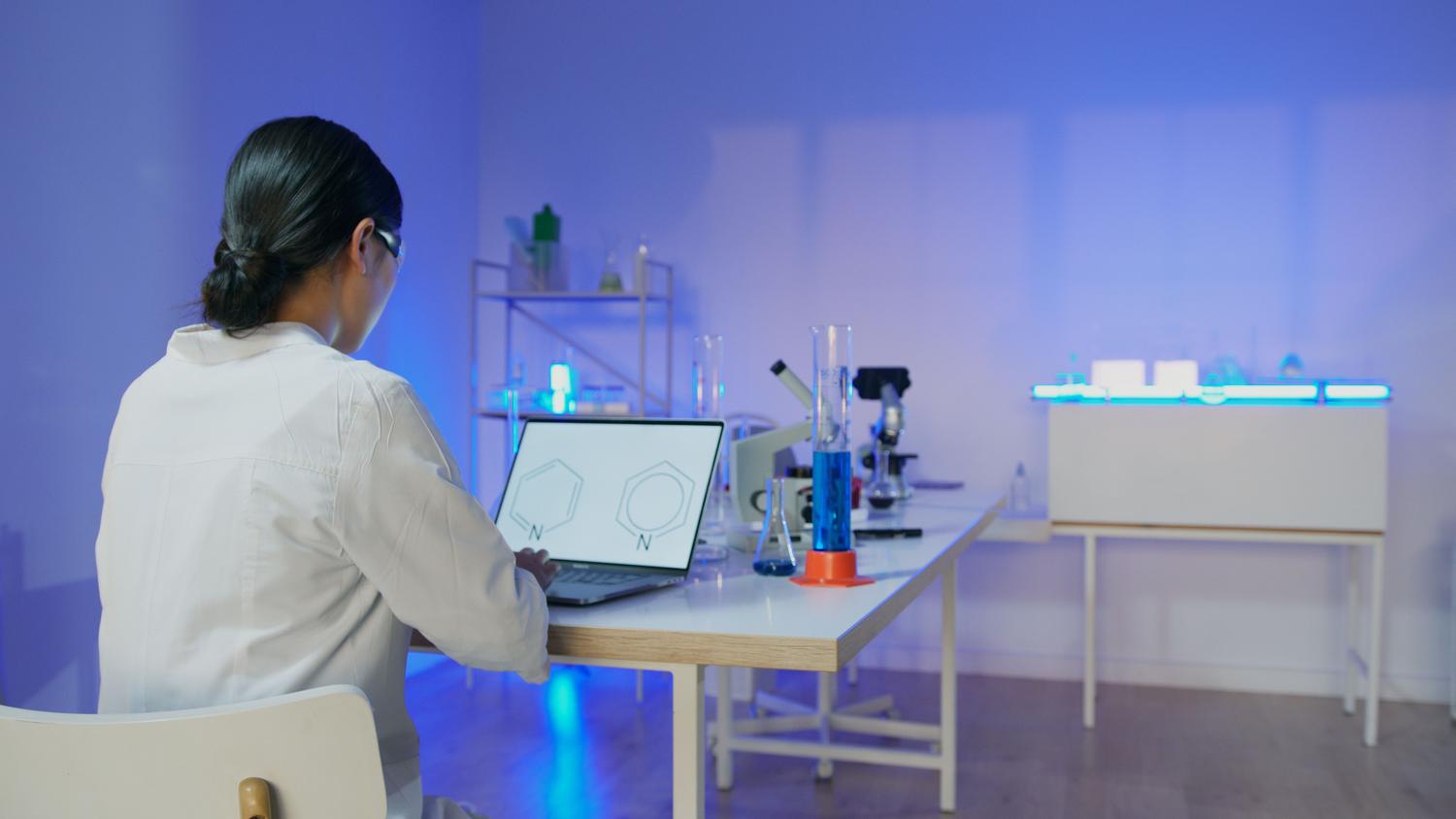 Científica analizando estructuras químicas en un ordenador portátil dentro de un laboratorio moderno, representando el perfil profesional de doble dominio en biología y código. Científica analizando estructuras químicas en un ordenador portátil dentro de un laboratorio moderno, representando el perfil profesional de doble dominio en biología y código.