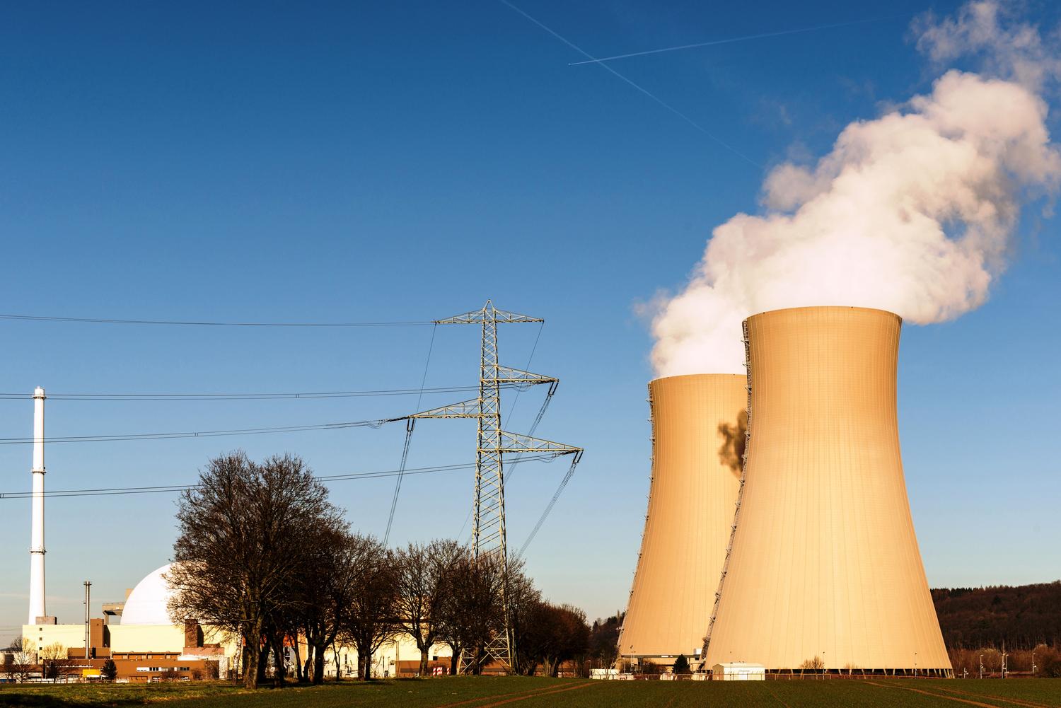 Vista panorámica de una central nuclear con torres de refrigeración, ilustrando las fuentes de energía constante y bajas emisiones de CO2. Vista panorámica de una central nuclear con torres de refrigeración, ilustrando las fuentes de energía constante y bajas emisiones de CO2.