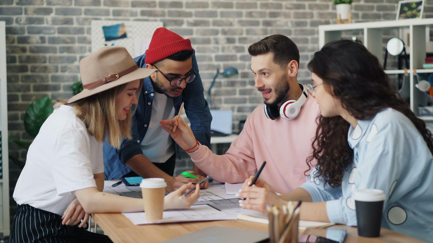 Equipo diverso de jóvenes profesionales colaborando en una sesión de brainstorming en una oficina moderna, representando el flujo de talento en el ecosistema startup. Equipo diverso de jóvenes profesionales colaborando en una sesión de brainstorming en una oficina moderna, representando el flujo de talento en el ecosistema startup.