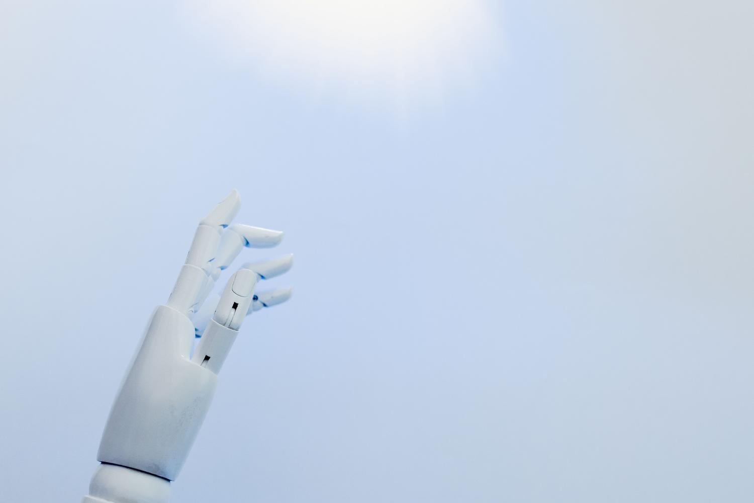 Mano robótica blanca alcanzando una luz brillante en un cielo azul, representando la innovación y el descubrimiento de una nueva era tecnológica. Mano robótica blanca alcanzando una luz brillante en un cielo azul, representando la innovación y el descubrimiento de una nueva era tecnológica.