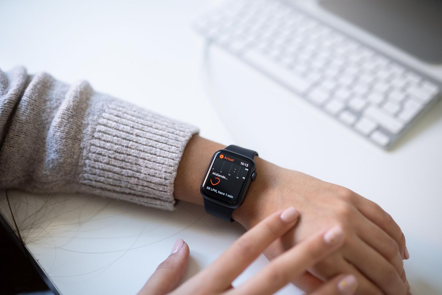 Persona monitoreando sus pulsaciones con un reloj inteligente en un entorno de oficina moderno, integrando la salud en la rutina laboral. Persona monitoreando sus pulsaciones con un reloj inteligente en un entorno de oficina moderno, integrando la salud en la rutina laboral.