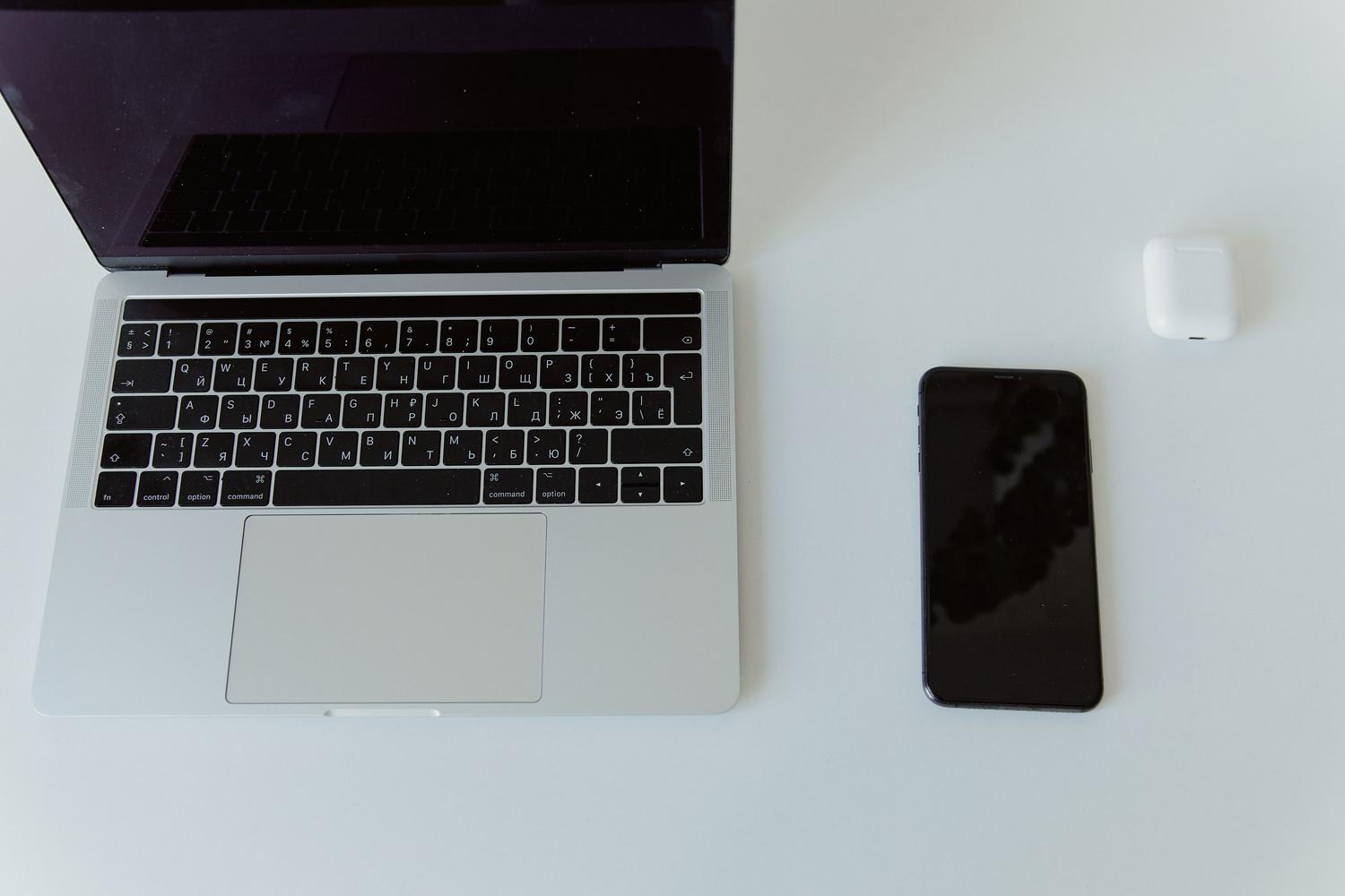 Espacio de trabajo minimalista con portátil y móvil, representando la sincronización de dispositivos. Espacio de trabajo minimalista con portátil y móvil, representando la sincronización de dispositivos.