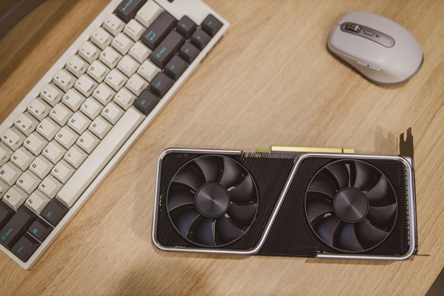 Tarjeta gráfica serie RTX 30 sobre un escritorio gaming junto a teclado y ratón, representando el entorno de prueba. Tarjeta gráfica serie RTX 30 sobre un escritorio gaming junto a teclado y ratón, representando el entorno de prueba.