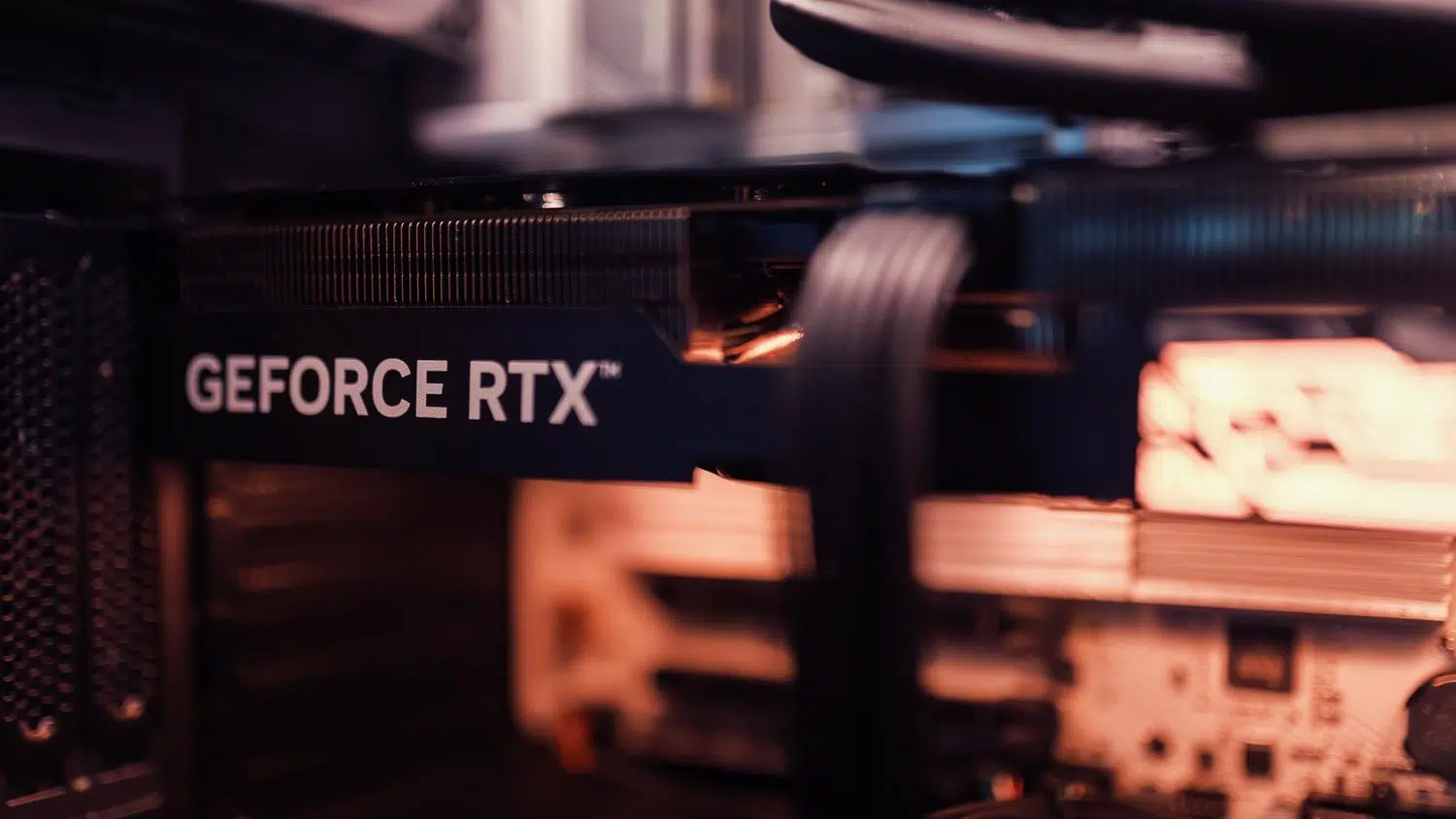 Primer plano macro del logotipo GeForce RTX en una tarjeta gráfica, resaltando la tecnología de hardware.