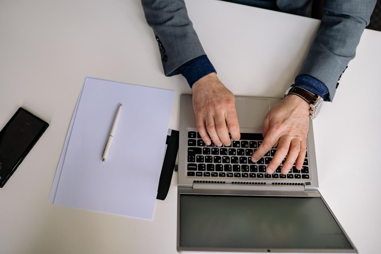 Persona en entorno profesional trabajando con un portátil y notas, ilustrando el soporte para empresas y anunciantes en TikTok for Business. Persona en entorno profesional trabajando con un portátil y notas, ilustrando el soporte para empresas y anunciantes en TikTok for Business.