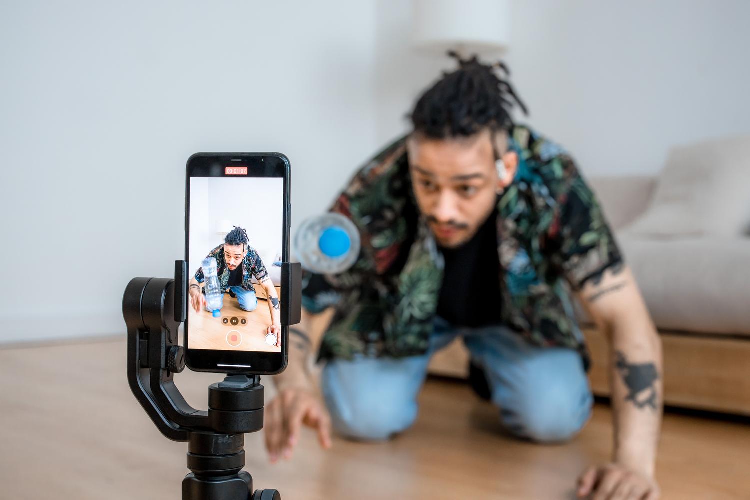 Creador de contenido grabando un vídeo creativo con un smartphone y un estabilizador gimbal en un entorno moderno. Creador de contenido grabando un vídeo creativo con un smartphone y un estabilizador gimbal en un entorno moderno.