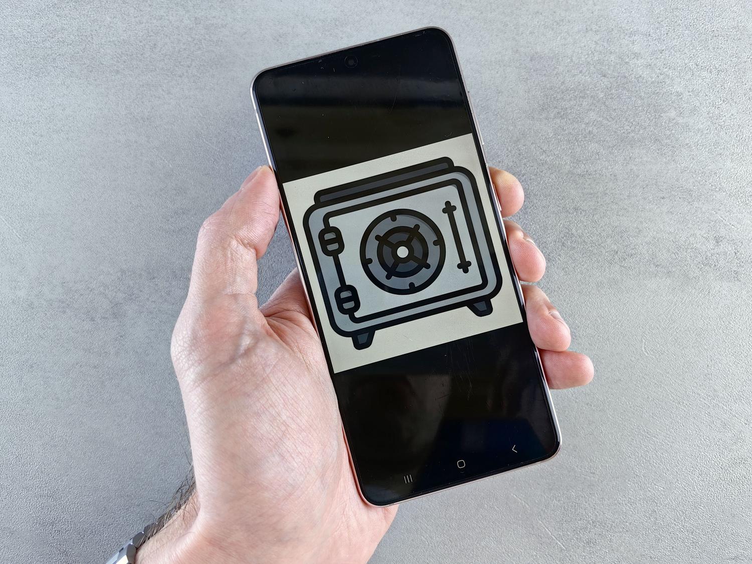 Pantalla de smartphone mostrando un icono de caja fuerte, representando el almacenamiento seguro y privado de archivos y apps. Pantalla de smartphone mostrando un icono de caja fuerte, representando el almacenamiento seguro y privado de archivos y apps.