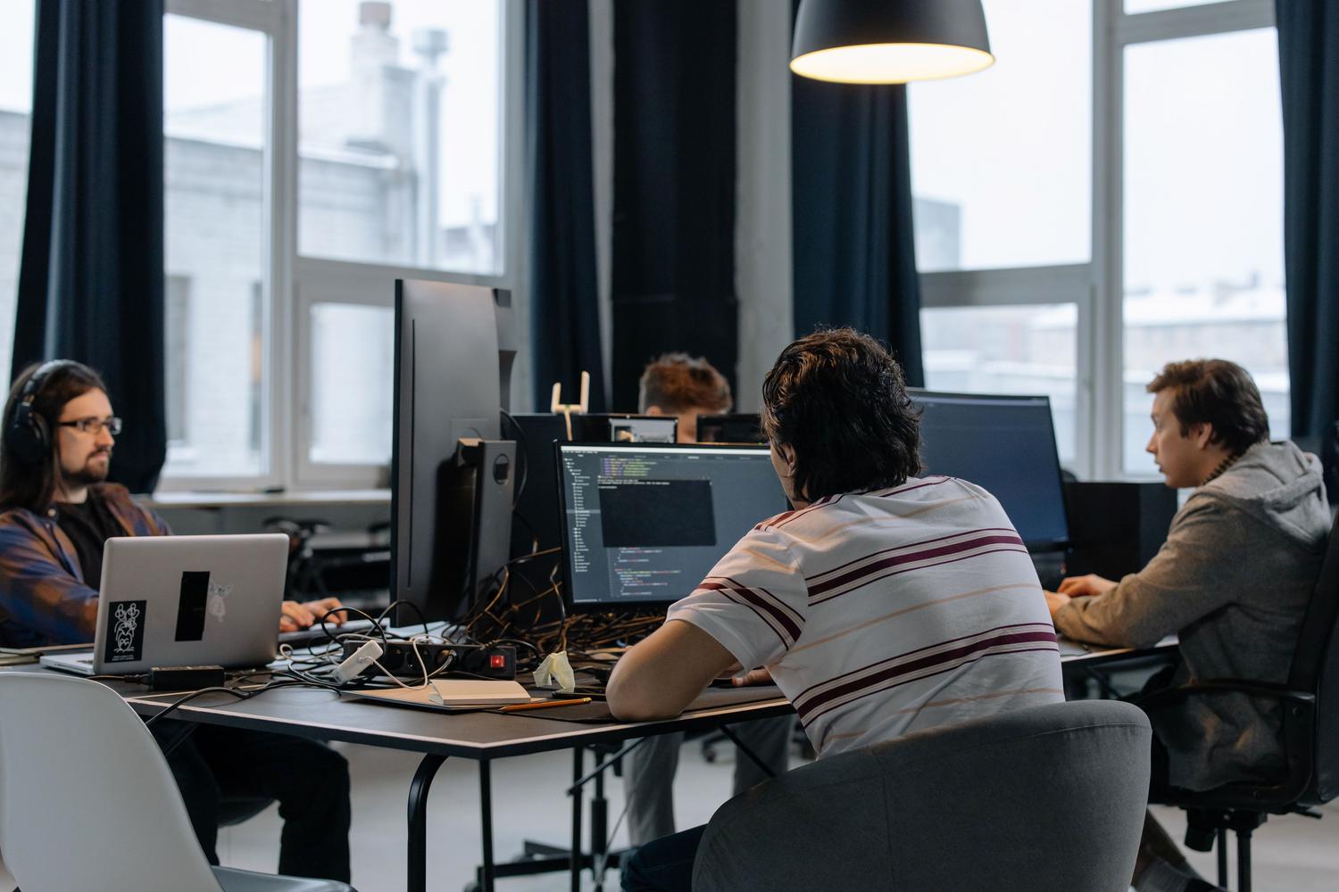 Equipo de programadores colaborando en una oficina tecnológica, reflejando la integración de la IA en los flujos de trabajo corporativos. Equipo de programadores colaborando en una oficina tecnológica, reflejando la integración de la IA en los flujos de trabajo corporativos.