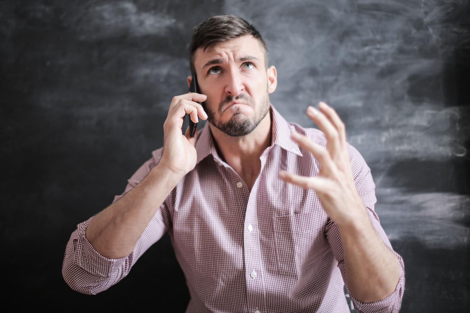 Hombre ansioso y frustrado durante una llamada telefónica, simbolizando la presión psicológica ejercida por los estafadores. Hombre ansioso y frustrado durante una llamada telefónica, simbolizando la presión psicológica ejercida por los estafadores.