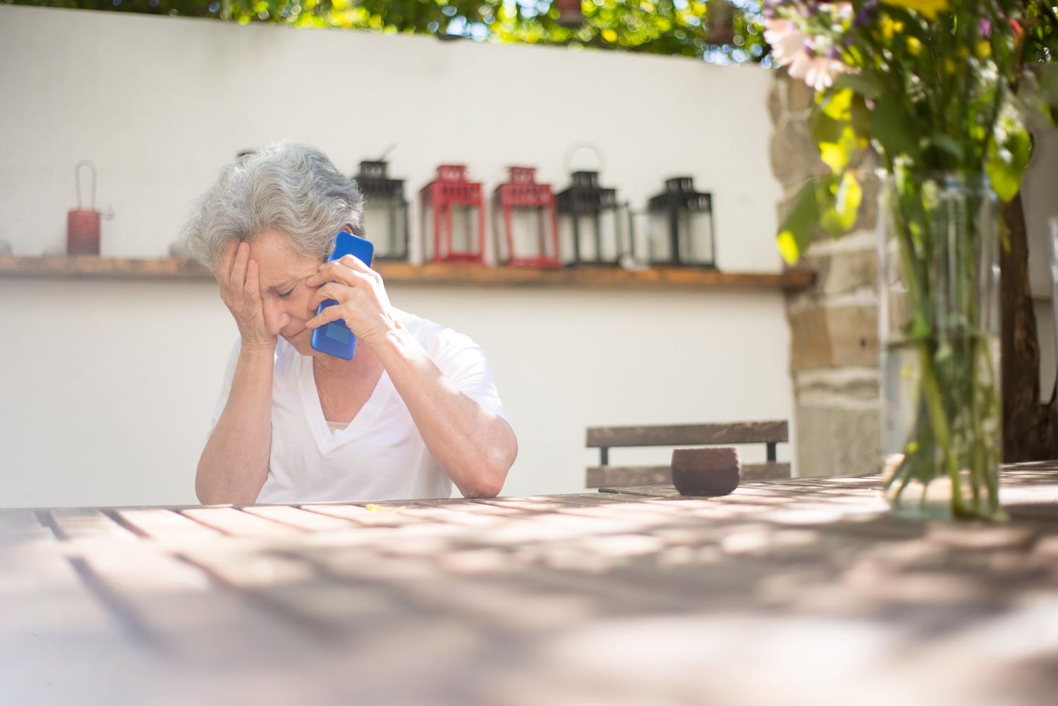 Mujer mayor con expresión de tristeza y preocupación al teléfono, reflejando la vulnerabilidad de los adultos mayores ante la clonación de voz. Mujer mayor con expresión de tristeza y preocupación al teléfono, reflejando la vulnerabilidad de los adultos mayores ante la clonación de voz.