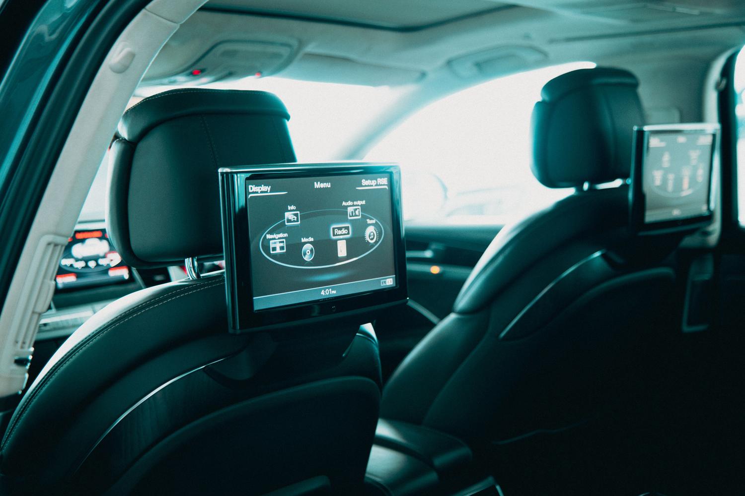 Interior de coche espacioso con pantallas de entretenimiento duales para los pasajeros traseros, ilustrando las funciones de cine y ocio en el vehículo. Interior de coche espacioso con pantallas de entretenimiento duales para los pasajeros traseros, ilustrando las funciones de cine y ocio en el vehículo.