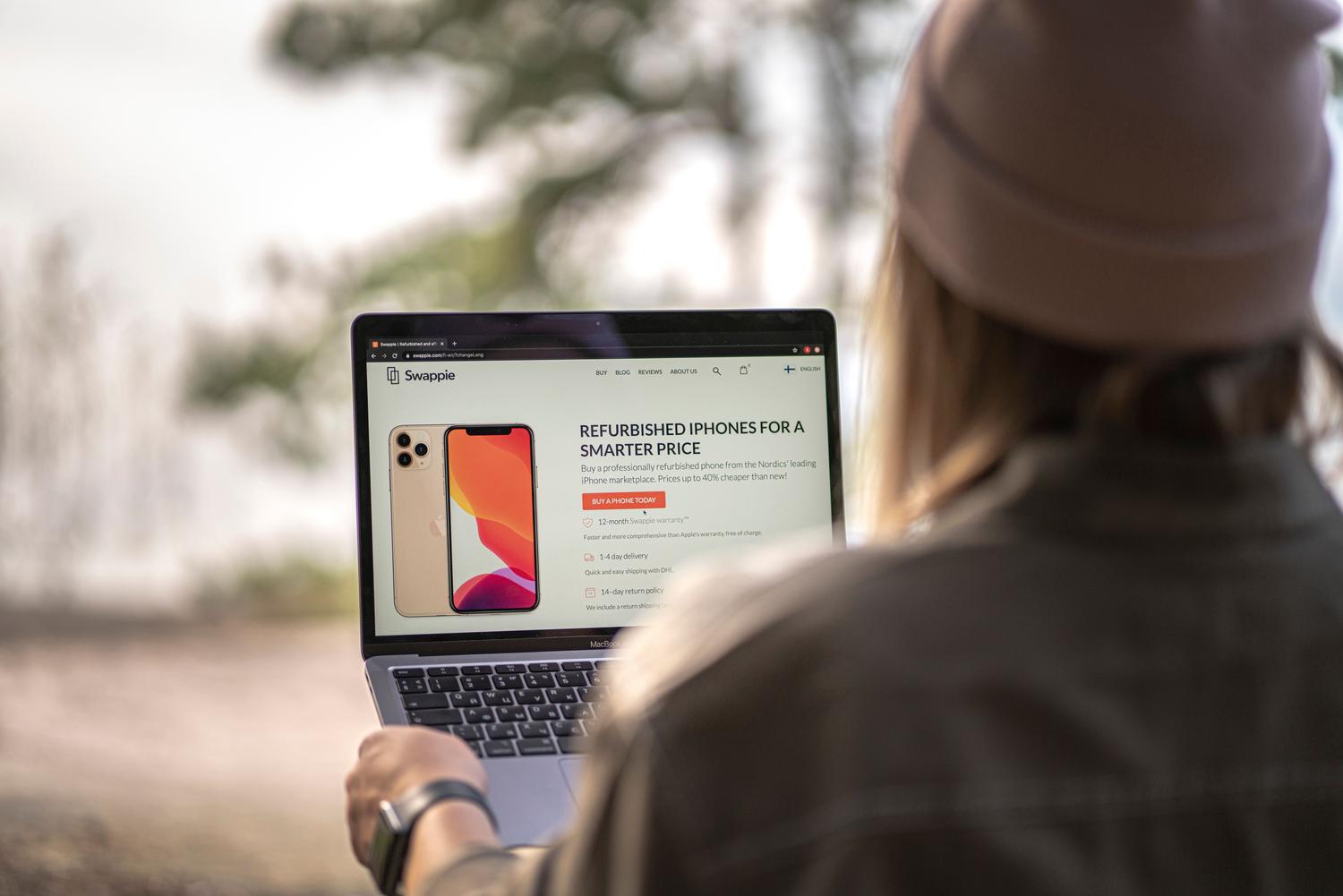 Una persona utilizando un ordenador portátil para buscar opciones de teléfonos reacondicionados, simbolizando una compra inteligente. Una persona utilizando un ordenador portátil para buscar opciones de teléfonos reacondicionados, simbolizando una compra inteligente.