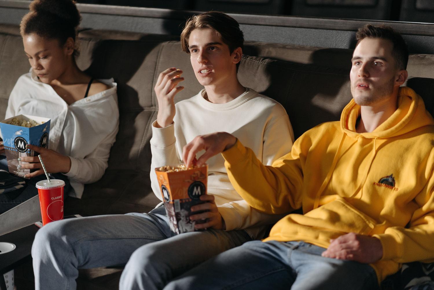 Grupo de amigos absortos viendo una película, transmitiendo la sensación de inmersión total que ofrece el sonido Dolby Atmos. Grupo de amigos absortos viendo una película, transmitiendo la sensación de inmersión total que ofrece el sonido Dolby Atmos.